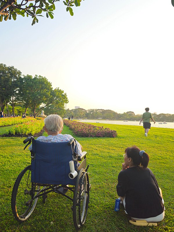 Elderly woman in wheelchair with caregiver